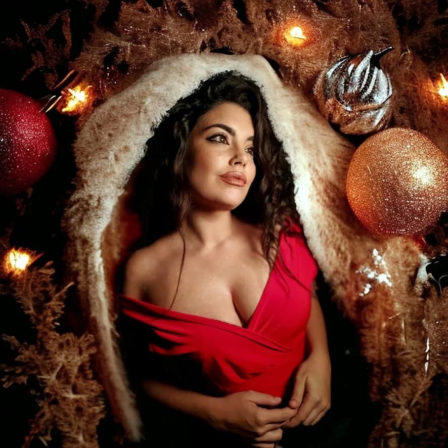 María Mendoza con vestido rojo en una imagen promocional navideña.